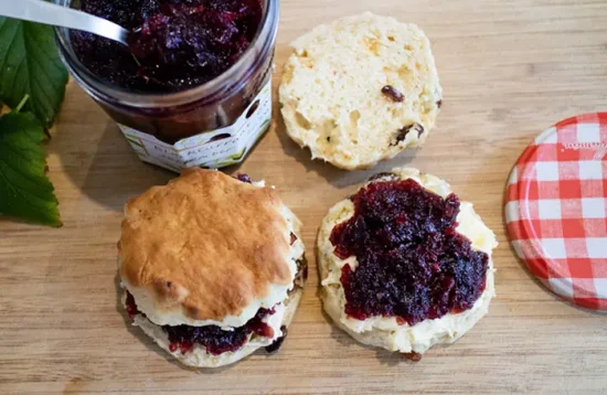 Blackcurrant jam on two scones from this blackcurrant jam recipe
