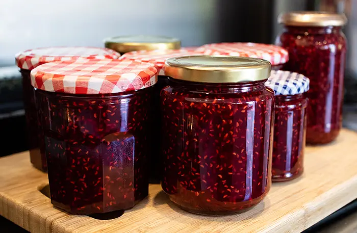 Jars of raspberry jam made using this easy recipe.