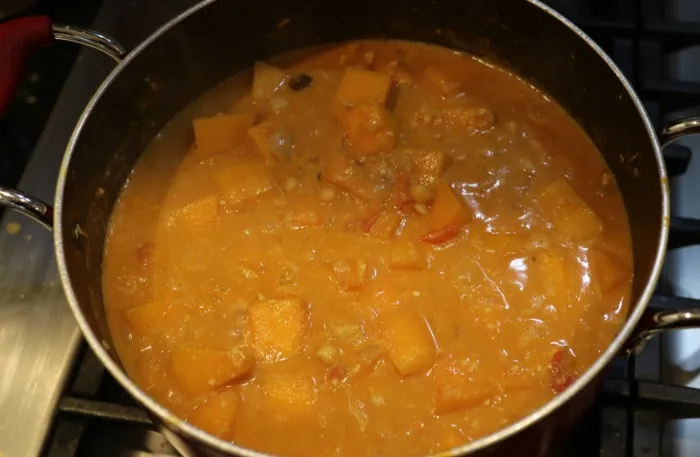 The cashew & butternut squash curry with coconut simmering in a large saucepan