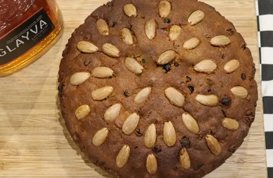 A Dundee cake next to a bottle of Glayva liqueur