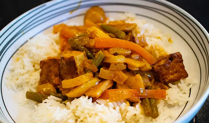 The Vegan Thai Curry served over rice in a white bowl. 