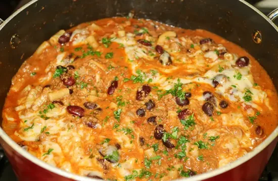 The One Pot Vegetarian Chili Mac and Cheese cooking in a red saucepan