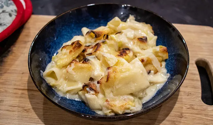 A portion of the Leek Pasta Bake - Served in a dark blue pasta dish. 